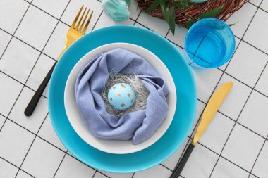 Paskalya yumurtası, çatal bıçak takımı ve cam tabakla servis edilir.