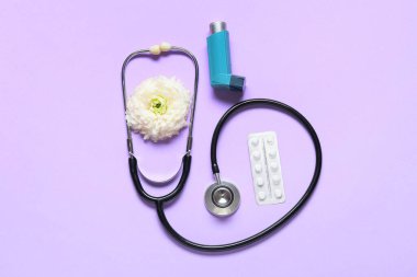 Stetoskop, astım spreyi, hap ve çiçek karışımı.