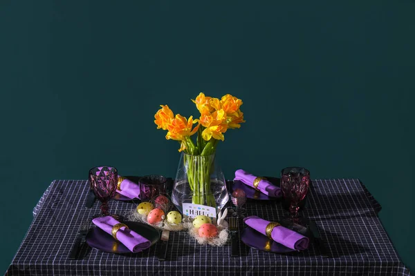 在绿墙旁边的桌上摆满了郁金香的漂亮的摆设和花瓶 — 图库照片