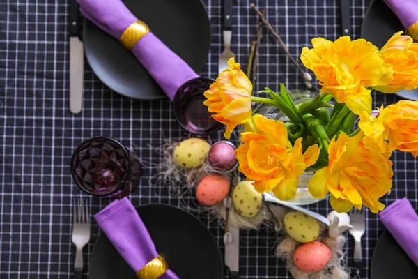Paskalya kutlaması için masanın üstünde bir buket sarı lale var.