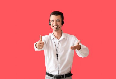 Çağrı merkezinin erkek danışmanı. Kulaklığı kırmızı arka planda.