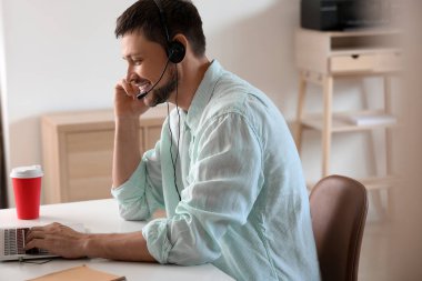 Ofiste çalışan kulaklıklı çağrı merkezinin danışmanı.