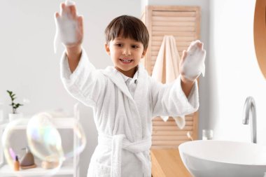 Banyoda ellerini yıkayan sevimli küçük çocuk.