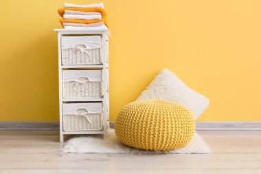 Modern pouf ve raf odası renk duvarının yanında.