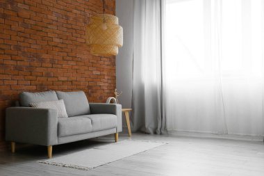 Modern oturma odasının içinde şık bir kanepe ve lamba var.