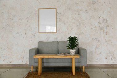 Modern oturma odasının içinde şık bir kanepe, masa ve çiçek var.
