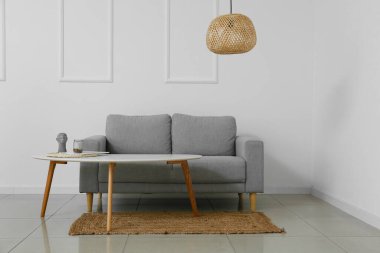 Modern ışıklı oturma odasının içinde şık bir kanepe ve lamba var.