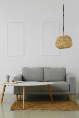 Modern ışıklı oturma odasının içinde şık bir kanepe ve lamba var.