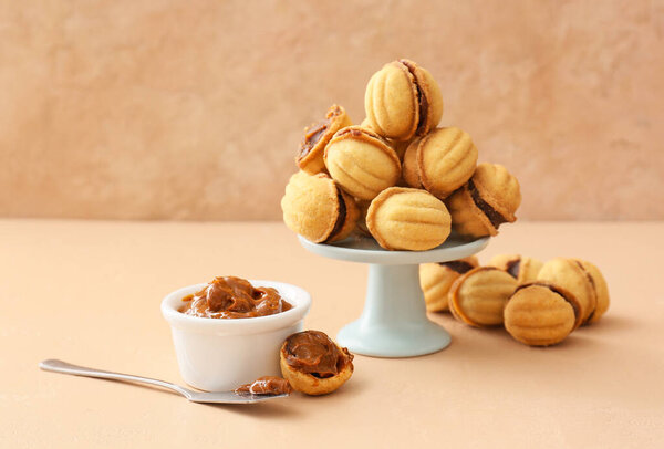 Tasty walnut shaped cookies with boiled condensed milk in dessert stand on table