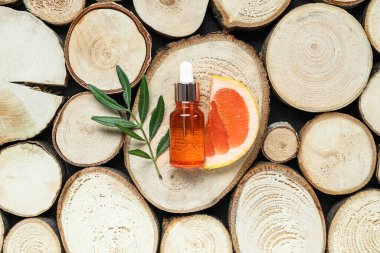 Ahşap arka planda bir şişe greyfurt yağı.