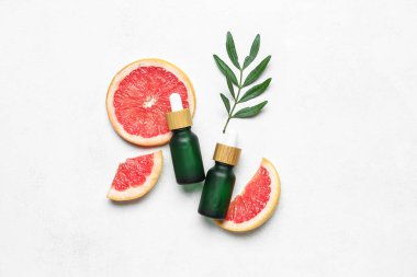Hafif arkaplanda greyfurt yağı şişeleri