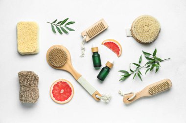 Hafif arka planda banyo malzemeleri olan greyfurt yağı şişeleri.