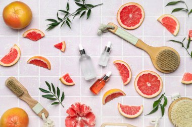 Renkli arkaplanda banyo malzemeleri olan greyfurt yağı şişeleri.