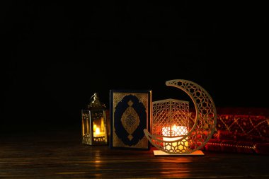 Parlak mumlu Arapça mum tutucu, fanatik lambalar ve koyu arkaplanda Kur 'an