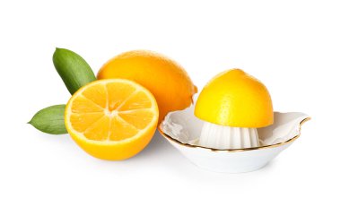 Beyaz zemin üzerinde seramik sıkacağı, portakal ve limon.