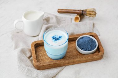 Bir bardak mavi kibrit çayı, arkaplanda barut ve kase.