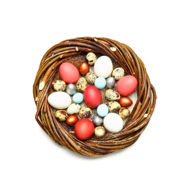 Beyaz arka planda boyanmış paskalya yumurtaları olan yuva