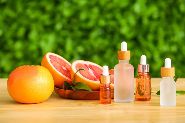 Bottles Essential Oil Ripe Grapefruits Wooden Table Outdoors — Stock Photo, Image