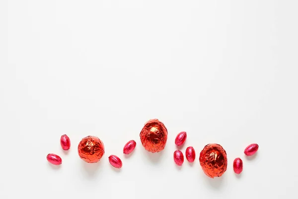 Huevos Pascua Chocolate Envueltos Papel Aluminio Rojo Sobre Fondo Blanco — Foto de Stock