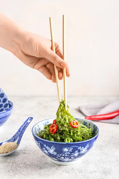 Mujer Comiendo Ensalada Algas Sanas Con Palillos Sobre Fondo Claro —  Fotos de Stock