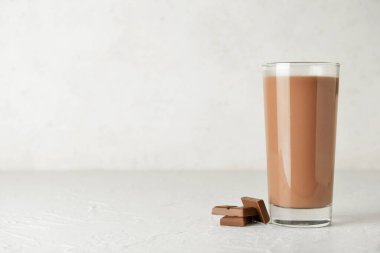 Beyaz arka planda bir bardak lezzetli çikolatalı süt.