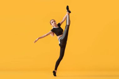 Güzel genç bir kadın renk arka planında jimnastik yapıyor.