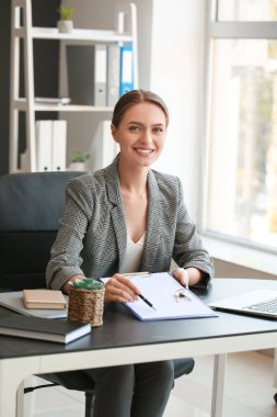 Ofiste panosu ve anahtarı olan bir emlakçı.