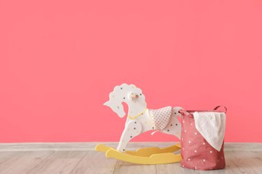 Sallanan at ve sepet renkli duvarın yanında ekoseli