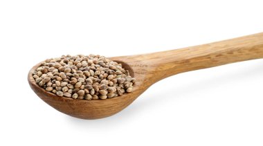 Beyaz arkaplanda kenevir tohumları olan kaşık