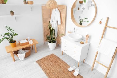 Lavabosu, aynası ve ahşap perdesi olan hafif banyonun içi.