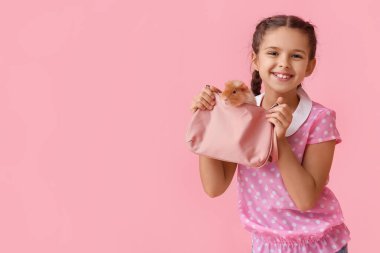 Pembe arka planda sevimli kobay çantalı küçük kız.