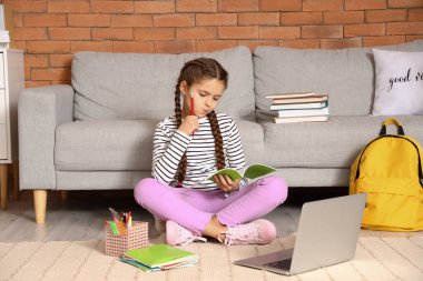 Düşünceli küçük kız evde online öğretmenle çalışıyor.