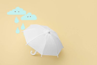 Beyaz şemsiyeli kompozisyon ve renkli arkaplanda kağıt bulutlar