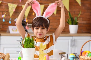 Evde Paskalyayı kutlayan tavşan kulaklı şirin bir çocuk.