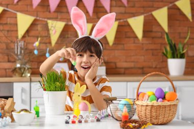 Tavşan kulaklı küçük mutlu çocuk Paskalyayı evde kutluyor.