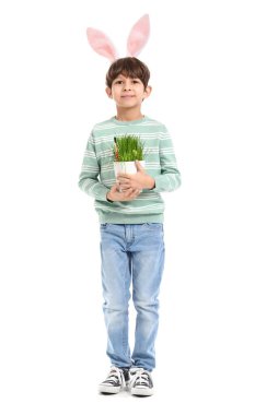 Tavşan kulaklı şirin çocuk beyaz arka planda çiçekleri tutuyor.