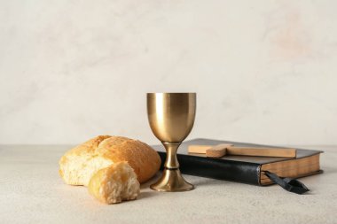 Ekmekli şarap, kutsal kitap ve arka planda haç.