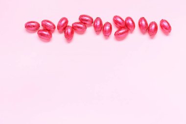 Tatlı çikolatalı Paskalya yumurtaları pembe arka planda