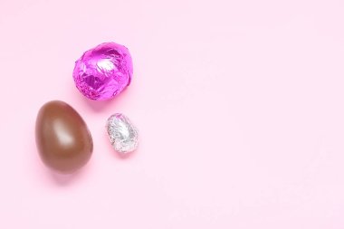 Tatlı çikolata yumurtaları pembe arka planda