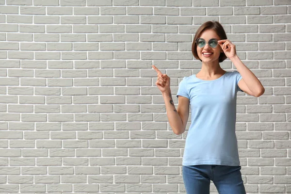 Beautiful Young Woman Stylish Shirt Pointing Something Brick Background — Stock Photo, Image