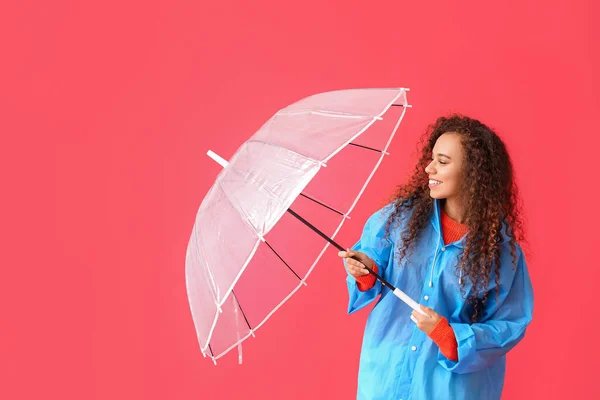 Joven Mujer Afroamericana Impermeable Azul Con Paraguas Sobre Fondo Rojo — Foto de Stock