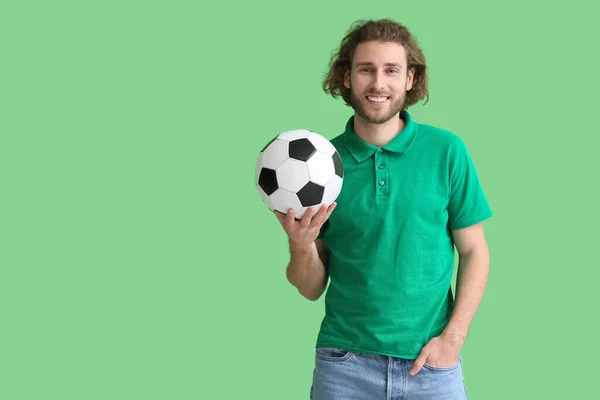 穿着T恤的英俊男子 背景是绿色的足球 — 图库照片