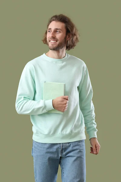 Usmívající Mladý Muž Knihou Zeleném Pozadí — Stock fotografie