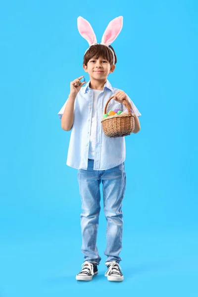 Netter Kleiner Junge Mit Hasenohren Und Ostereiern Korb Auf Farbigem — Stockfoto