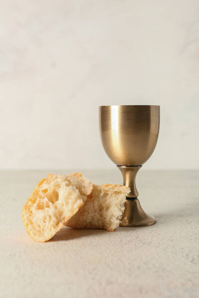 Cup of wine with bread on light background
