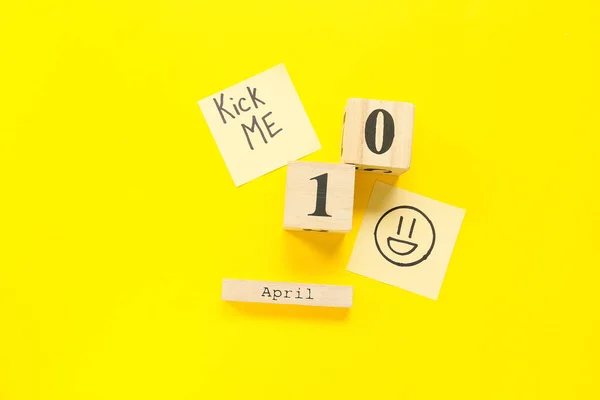 日期为4月1日的立方体日历和带有黄色背景的文本Kick Me的粘贴注释 — 图库照片