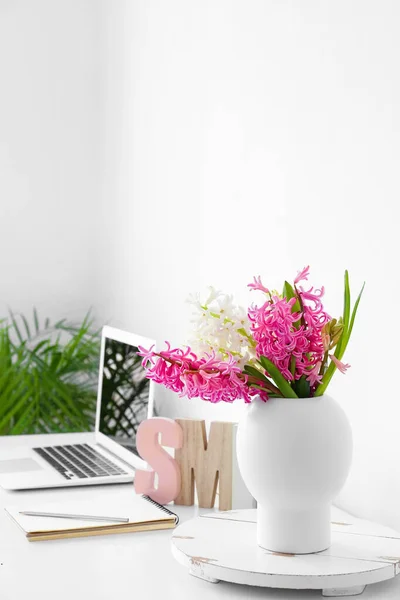 Prachtige Hyacint Bloemen Tafel Met Moderne Laptop Nabij Witte Muur — Stockfoto
