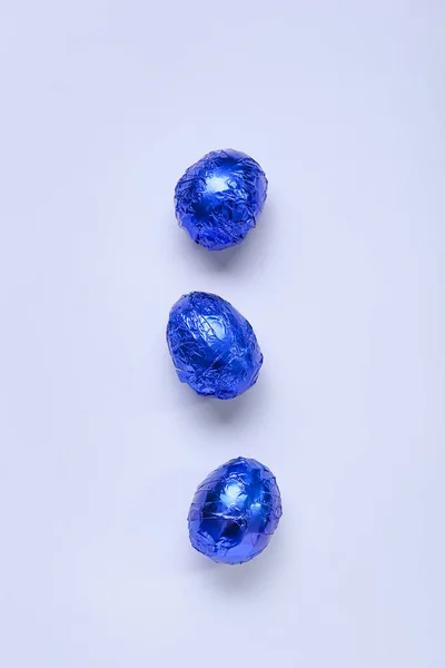 Leckere Schokoladeneier Blauer Folie Auf Farbigem Hintergrund — Stockfoto