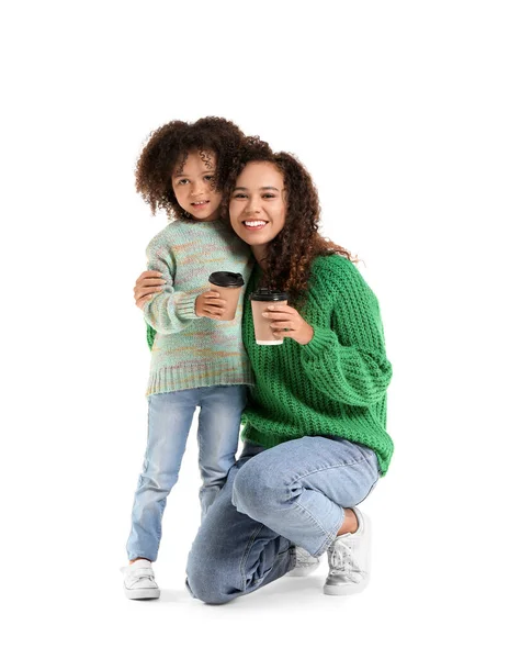 小非洲裔美国女孩和她的母亲穿着毛衣 背景是白色的热可可杯 — 图库照片