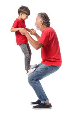 Kırmızı tişörtlü küçük çocuk ve dedesi beyaz arka planda.